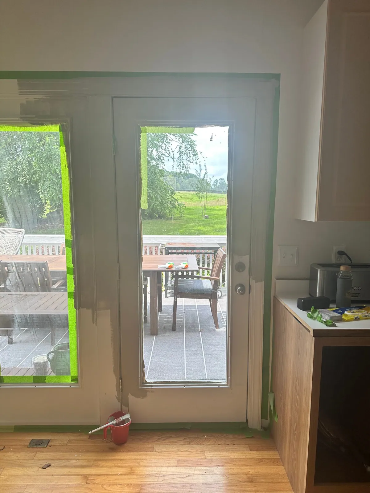 Door frame masked off with painter tape during a kitchen paint project