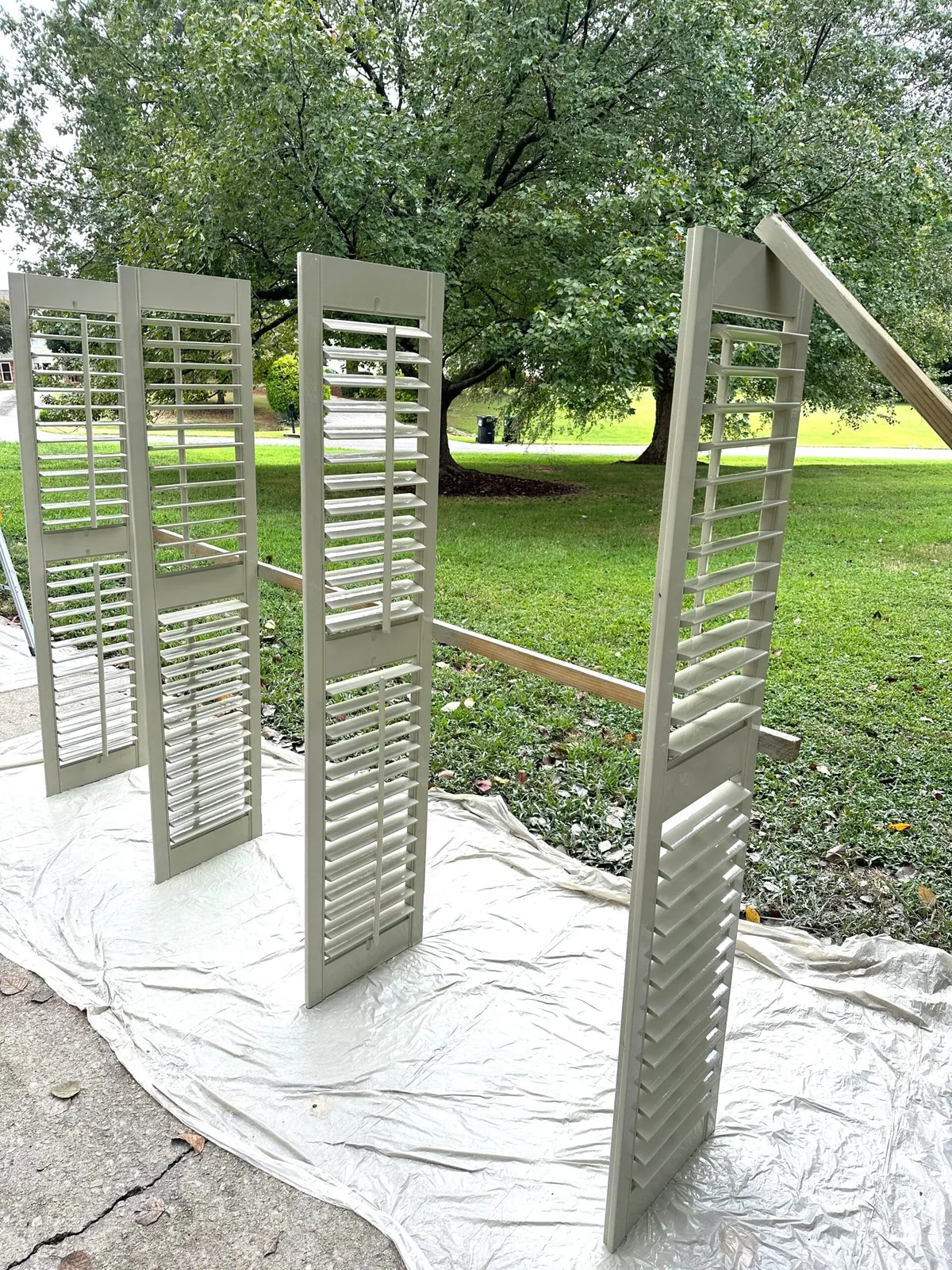 Interior shutters set out on a drop cloth to dry after painting