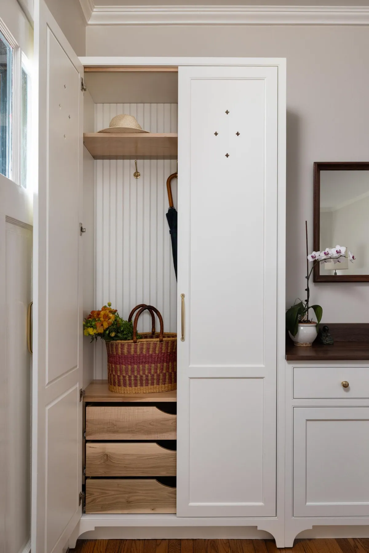 Mudroom cabinetry with hooks, open drawers and a shelf above the bench