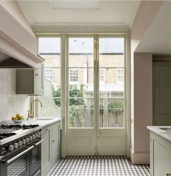 Sage green kitchen with French doors, a brass faucet and a checkerboard tile floor