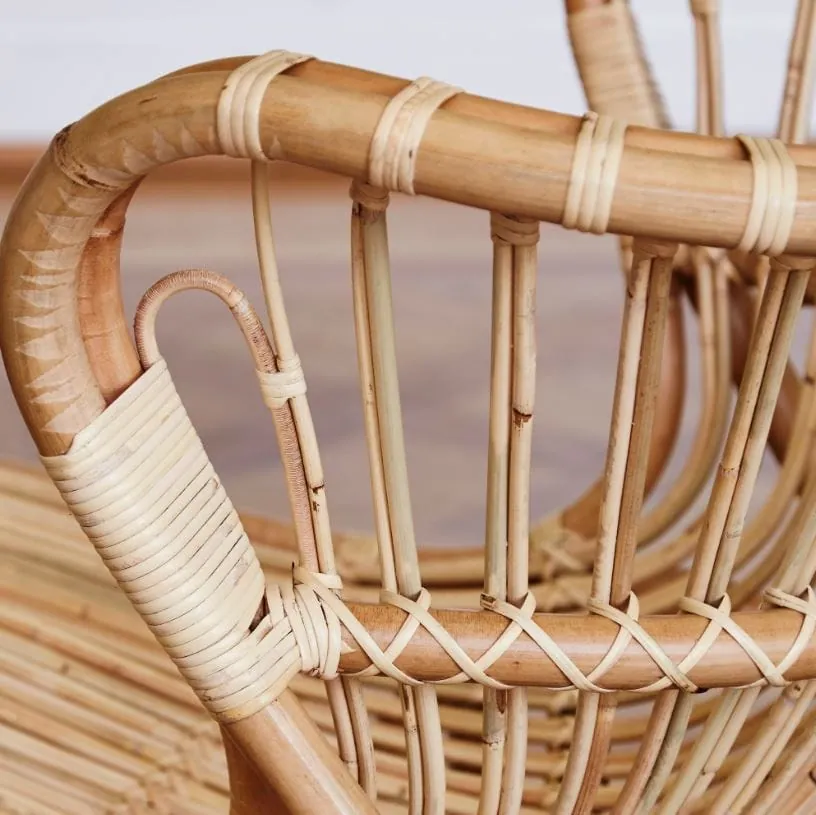 Close view of a rattan chair frame showing the wrapped joints and curved back