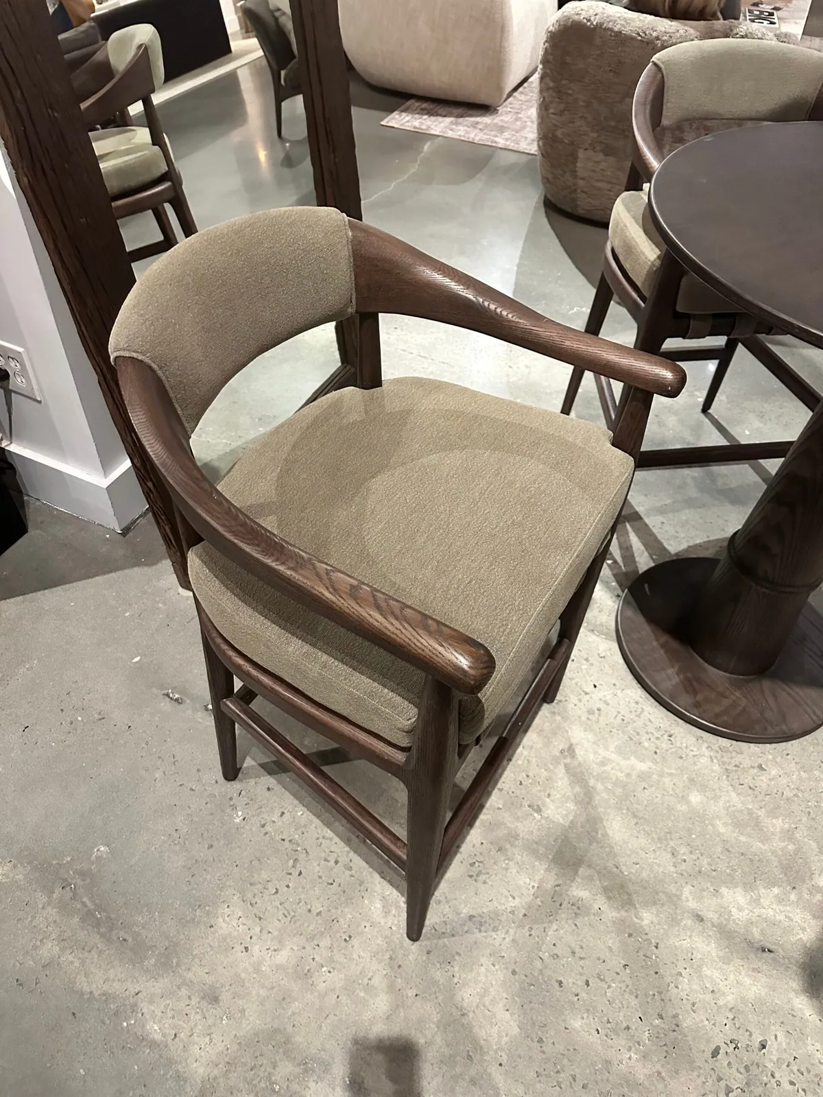 Wood-framed dining armchair with an upholstered seat in a furniture showroom