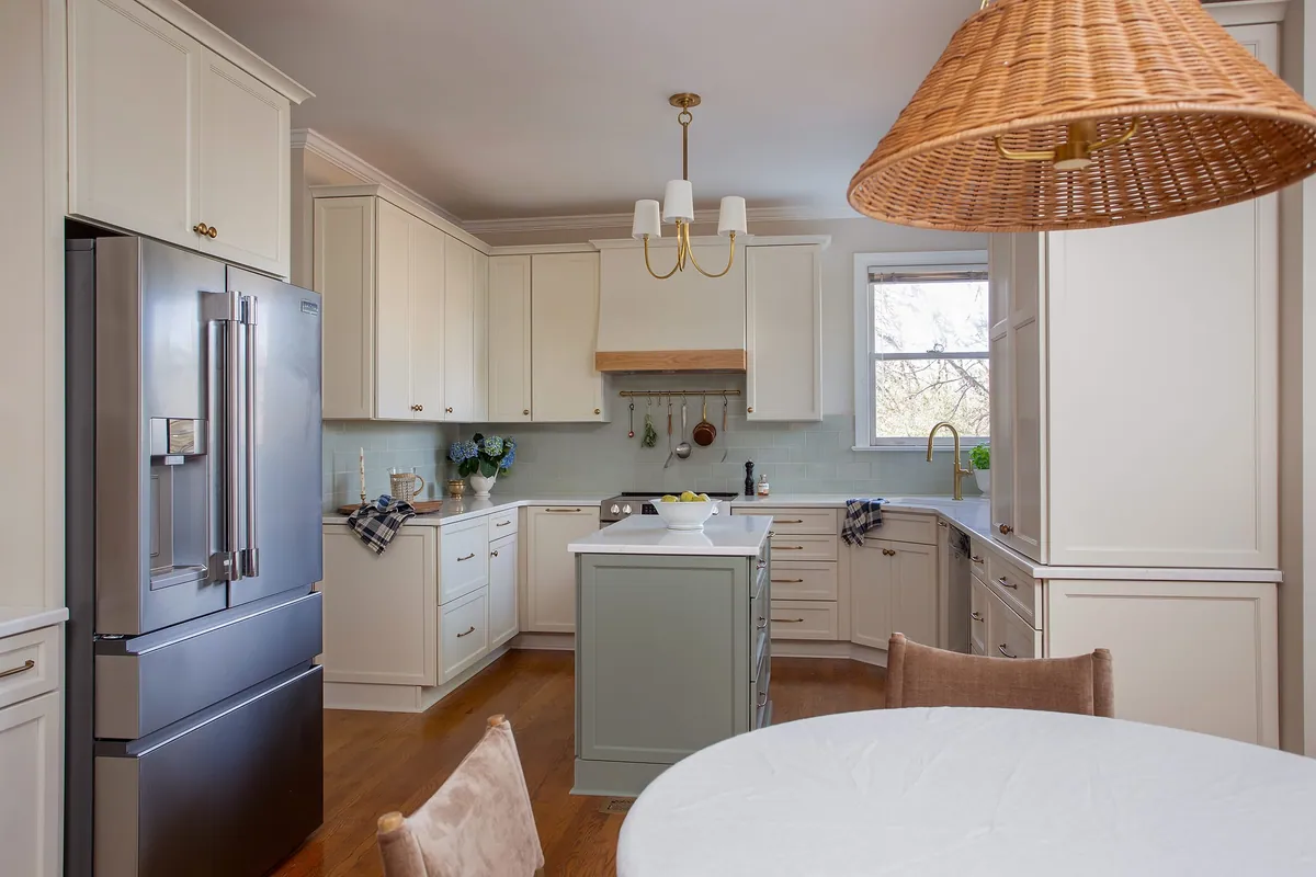 Kitchen with a woven rattan pendant, pale blue backsplash and a round breakfast table