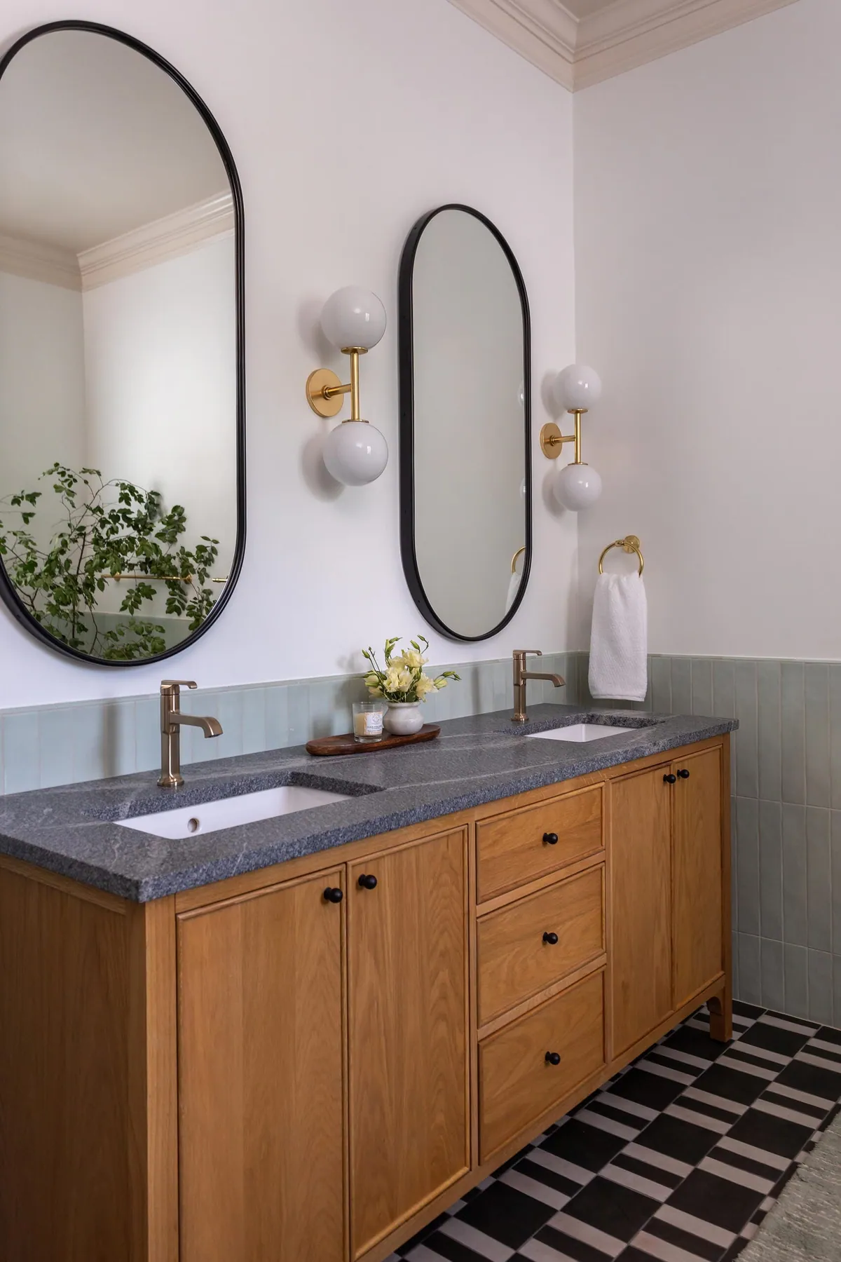 White oak double vanity with oval mirrors in a celadon primary bathroom
