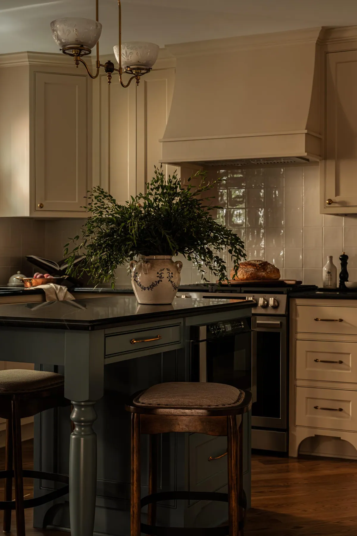 Gray-blue kitchen island with turned legs and leather topped counter stools
