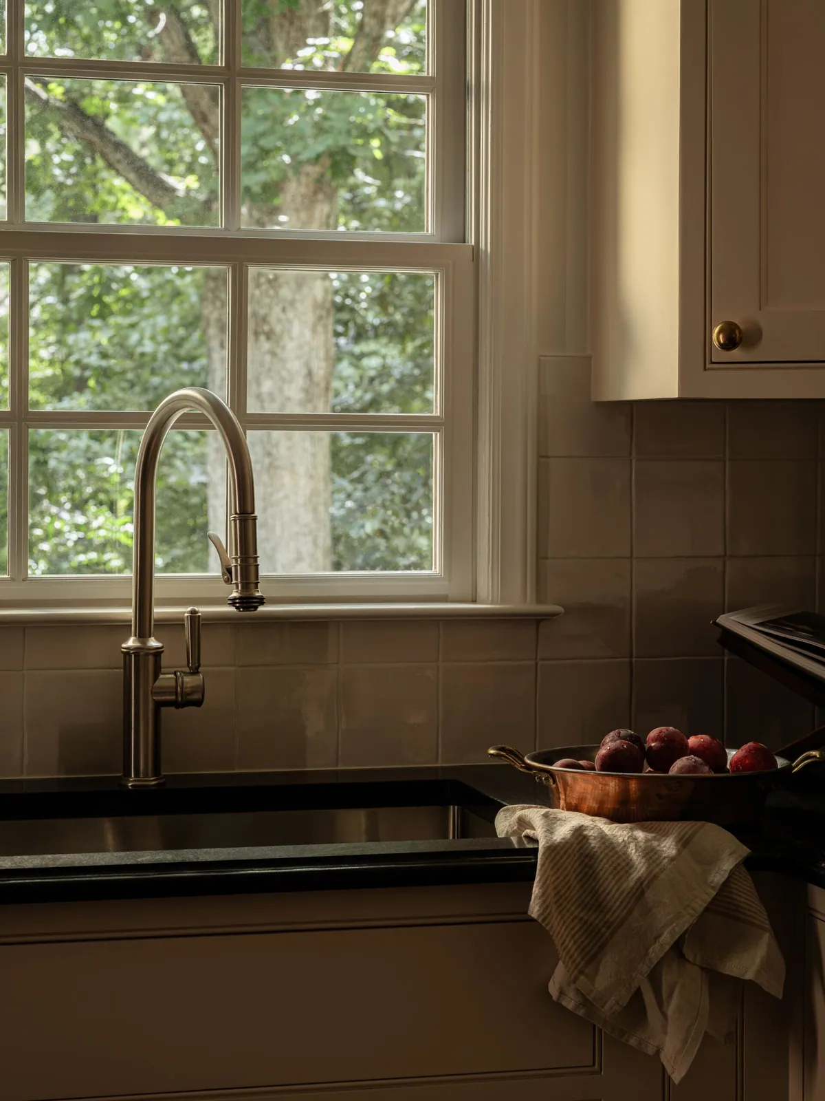 Gooseneck faucet at a divided light window above a soapstone counter