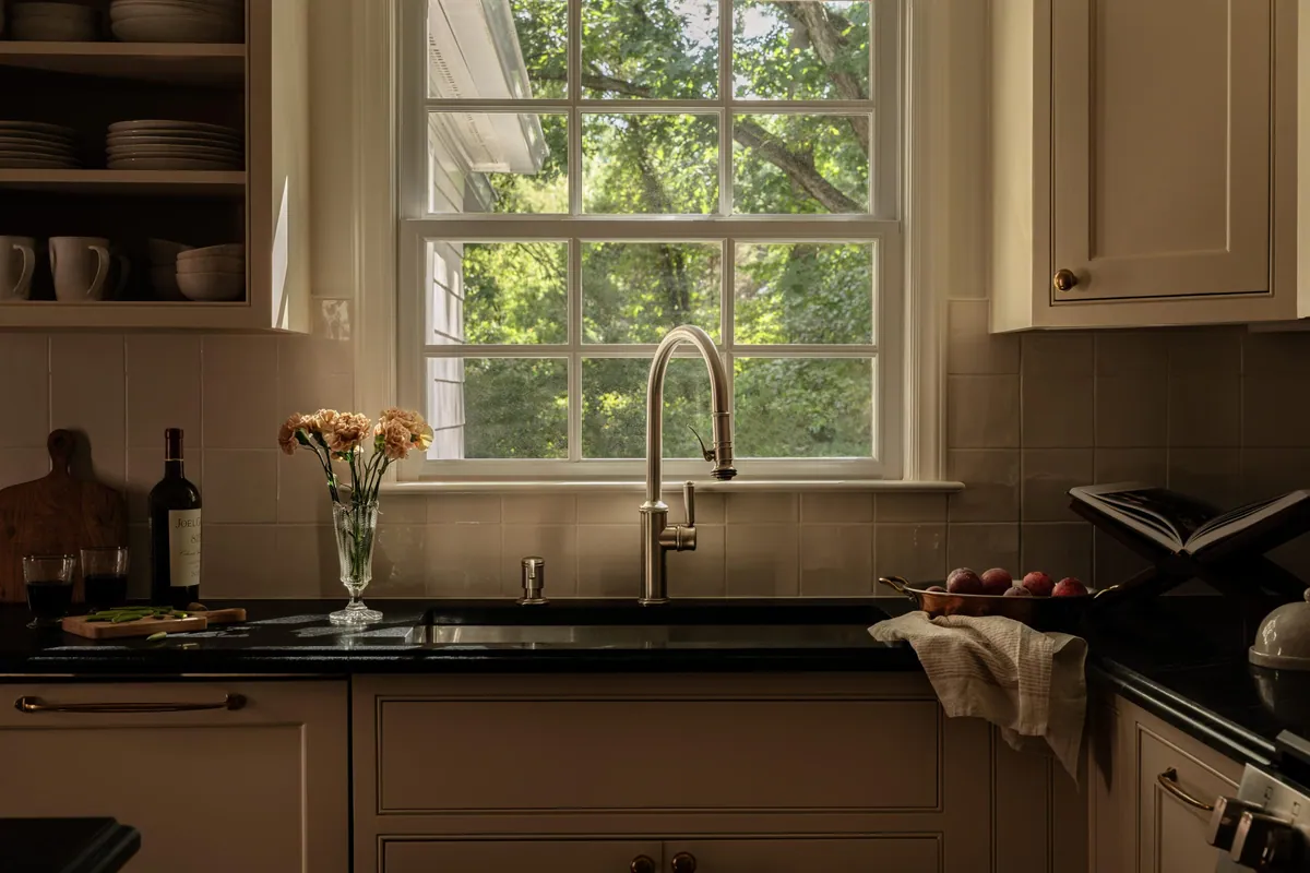 Kitchen sink wall with open shelving, stoneware and a window over the sink