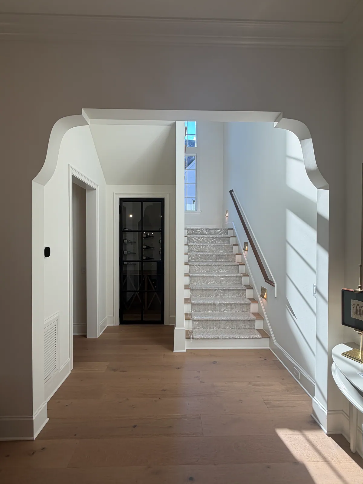 Shaped arched opening framing a hallway that leads to the stair