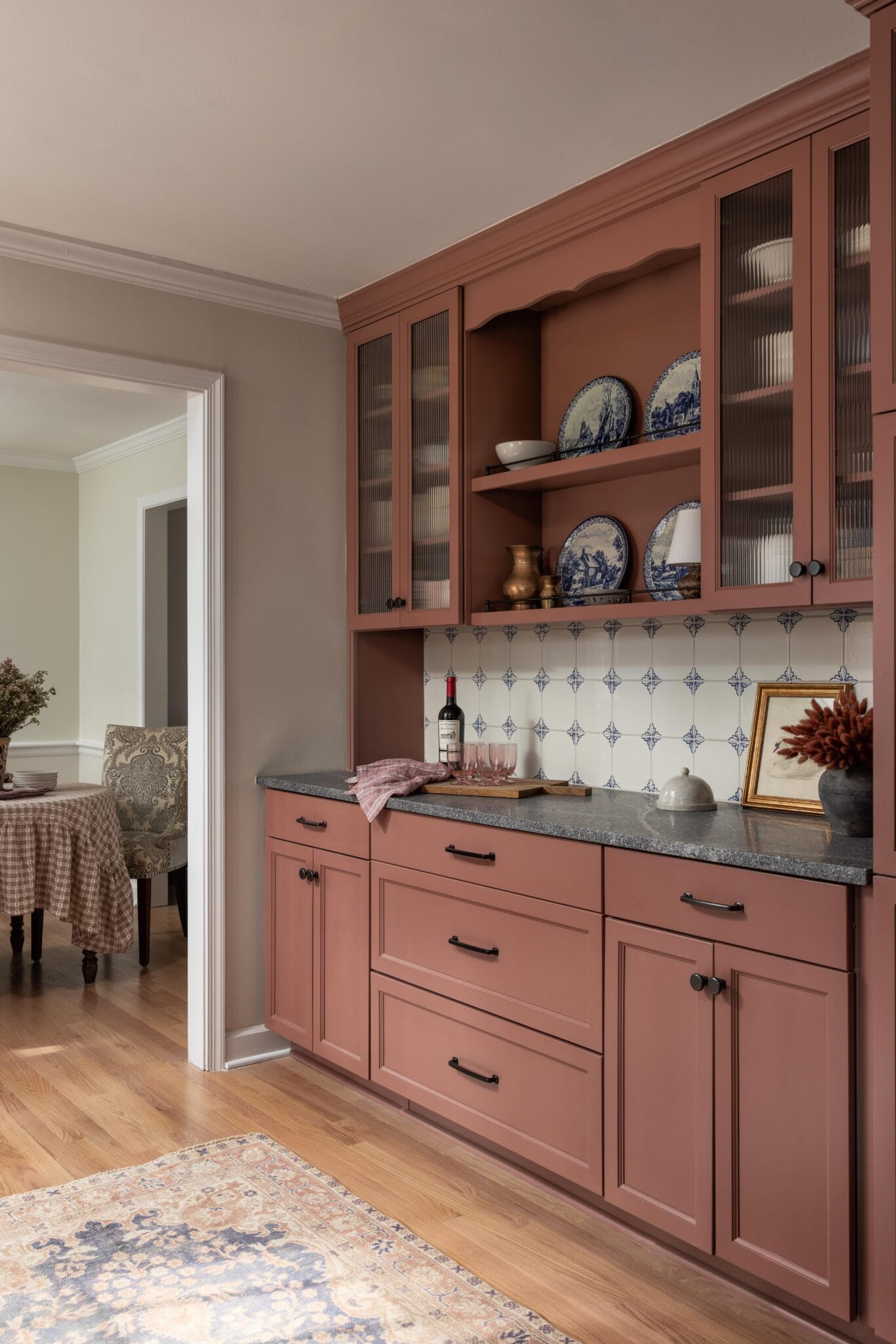 Built-in pink hutch with glass uppers opening to the dining room beyond