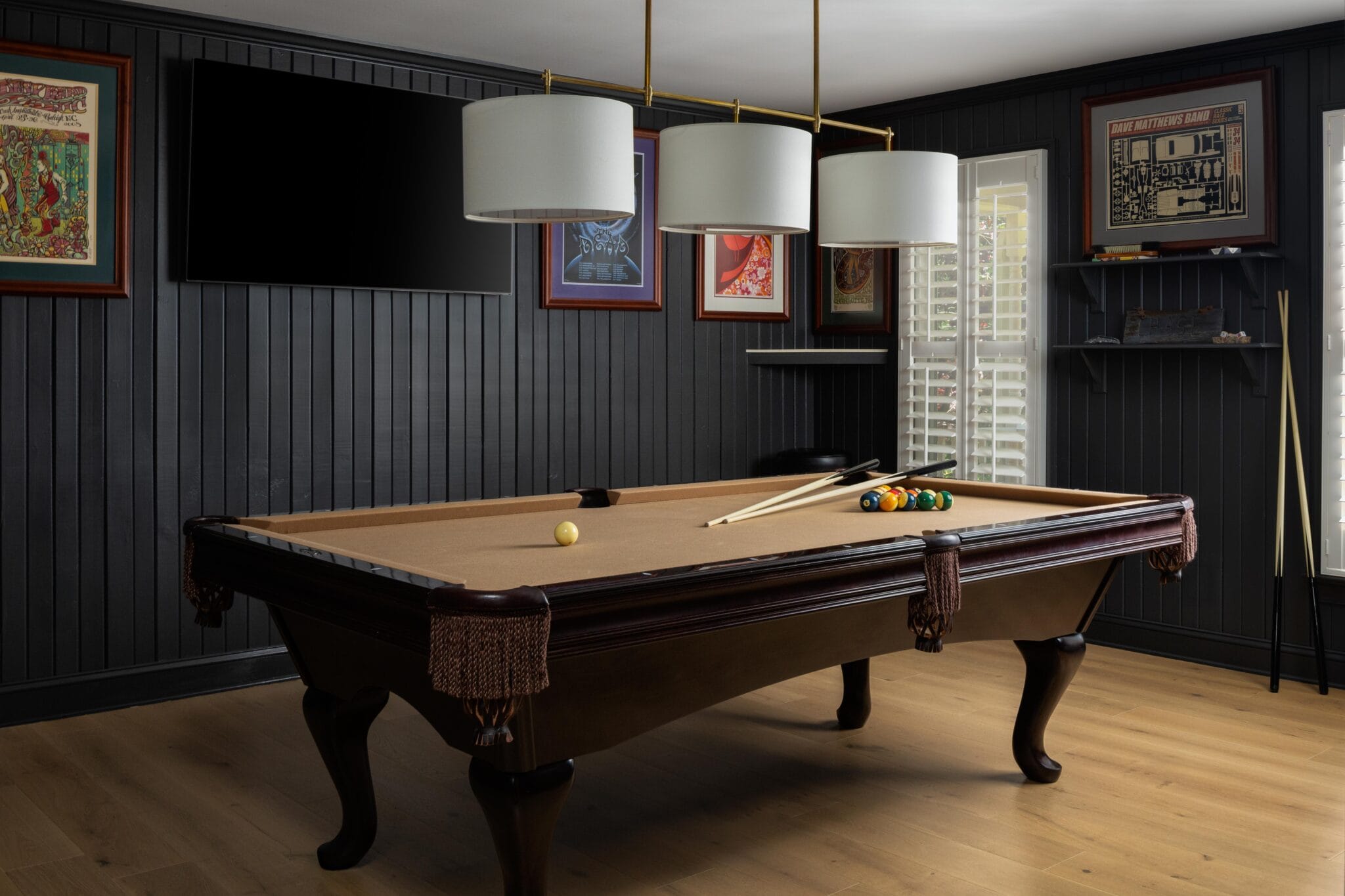 Game room with black shiplap walls, a billiards table and triple drum pendants