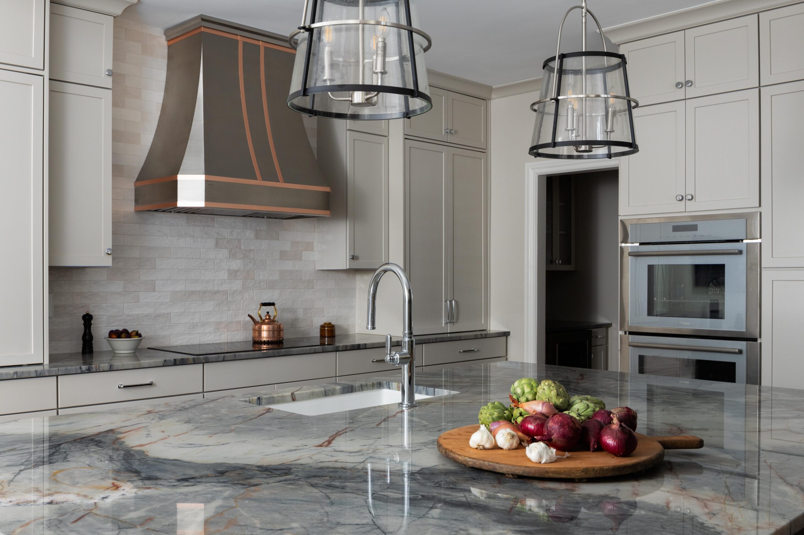 North Raleigh kitchen with quartzite island, copper range hood, and custom white cabinetry