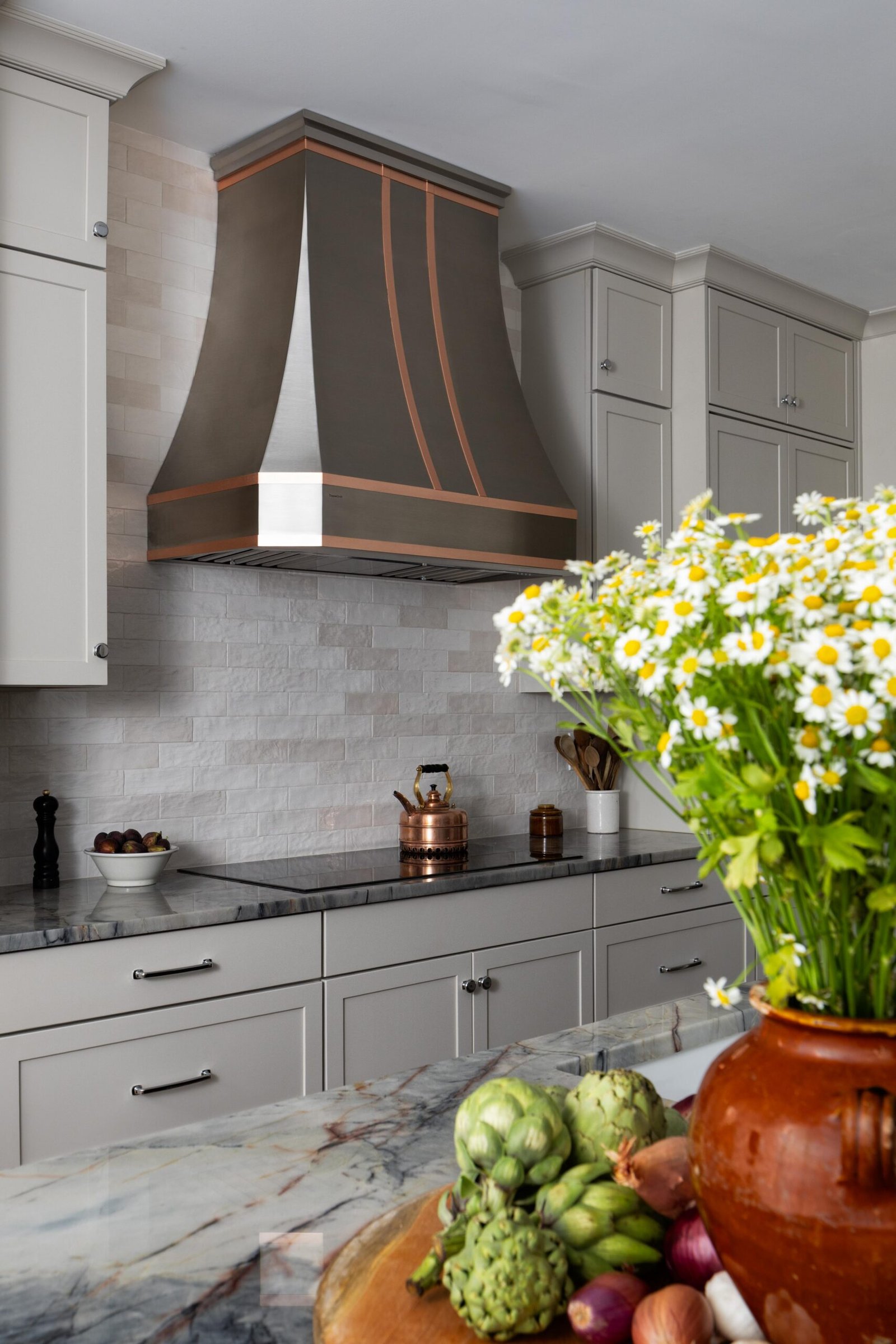 North Raleigh kitchen with marble island, copper range hood, and custom white cabinetry